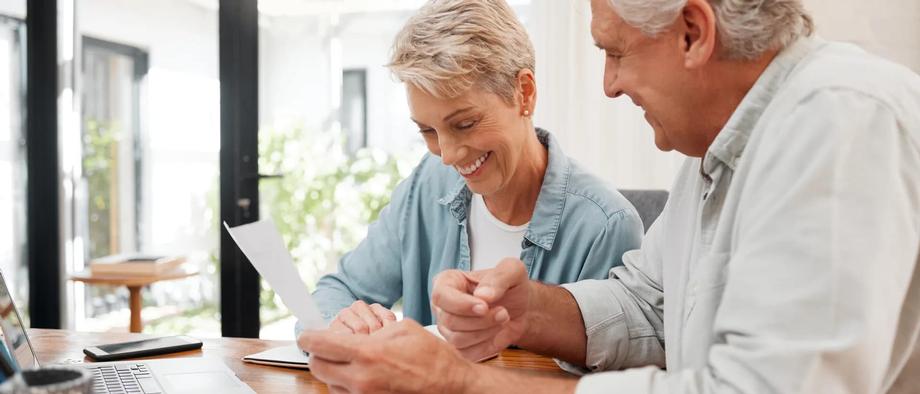 Retired couple reviewing retirement paperwork together at home